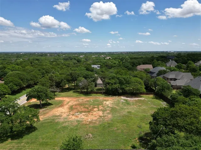 a swimming pool with lots of green space and trees in the background