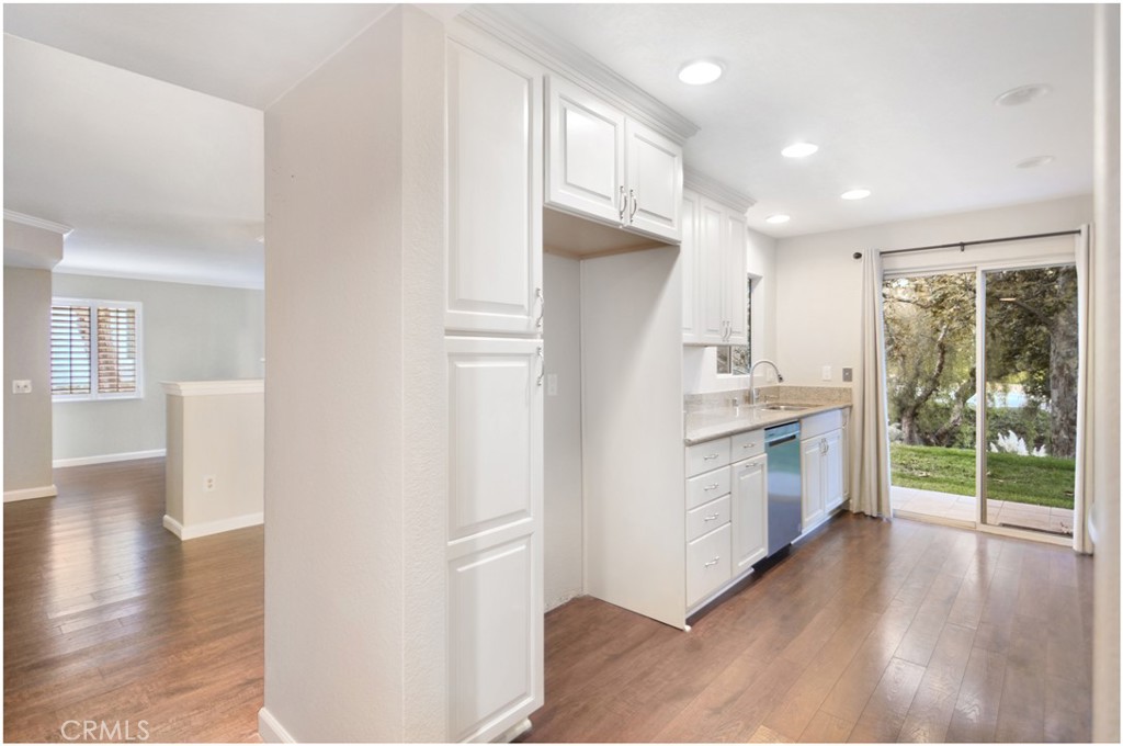 4 Corniche Drive, Unit B Dana Point, CA 92629 - Photo 12 of 41 a kitchen with white cabinets and wooden floor