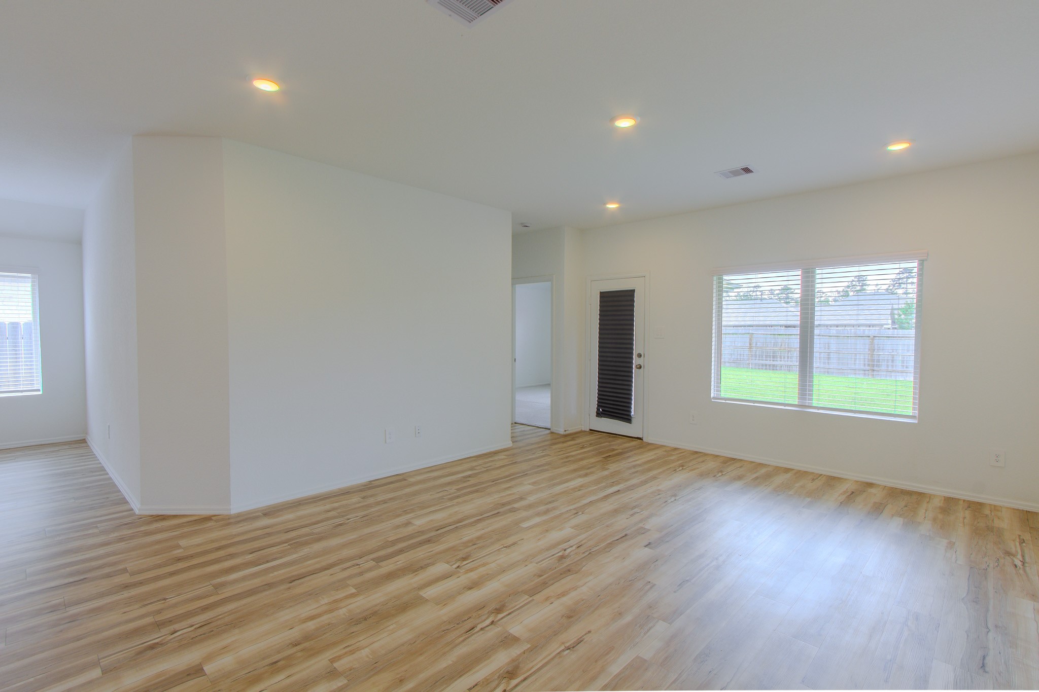 3113 Catalonion Court Conroe, TX 77301 - Photo 17 of 45 a view of an empty room with wooden floor and a window