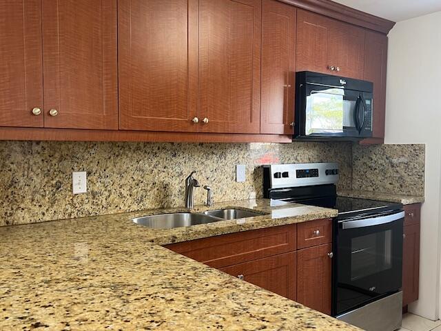 5500 Northwest 2nd Avenue, Unit 123 Boca Raton, FL 33487 - Photo 3 of 48 a kitchen with stainless steel appliances granite countertop a sink stove and cabinets