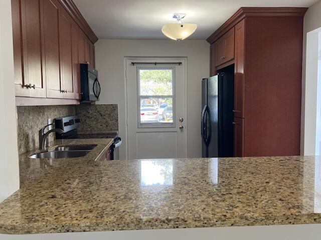 5500 Northwest 2nd Avenue, Unit 123 Boca Raton, FL 33487 - Photo 7 of 48 a kitchen with granite countertop a refrigerator stove and cabinets