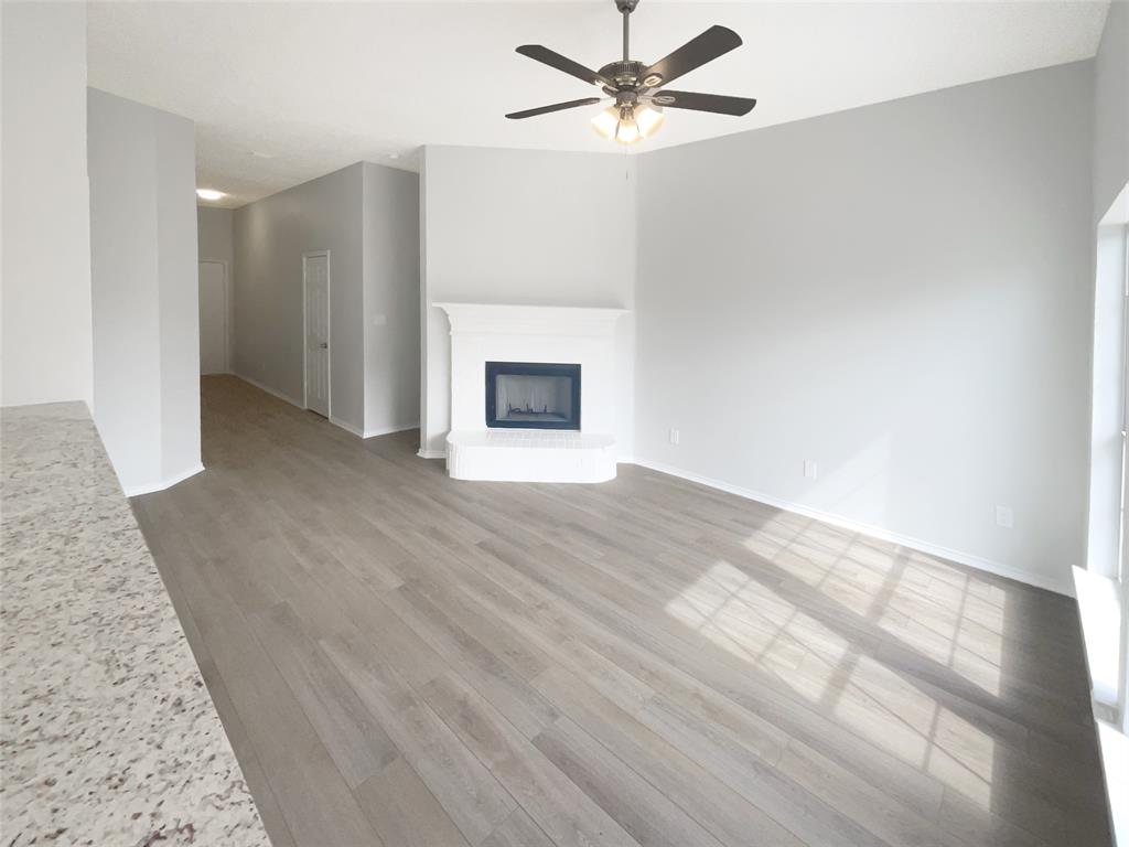 3724 Tulip Tree Drive Fort Worth, TX 76137 - Photo 11 of 30 wooden floor in an empty room with a fireplace