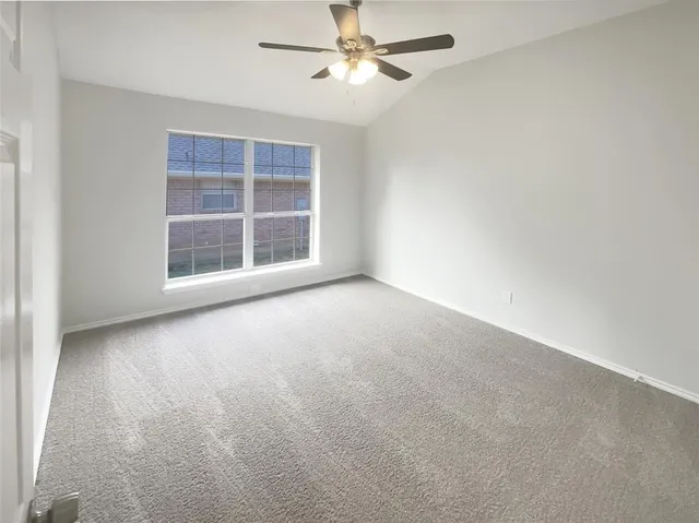 an empty room with windows and fan
