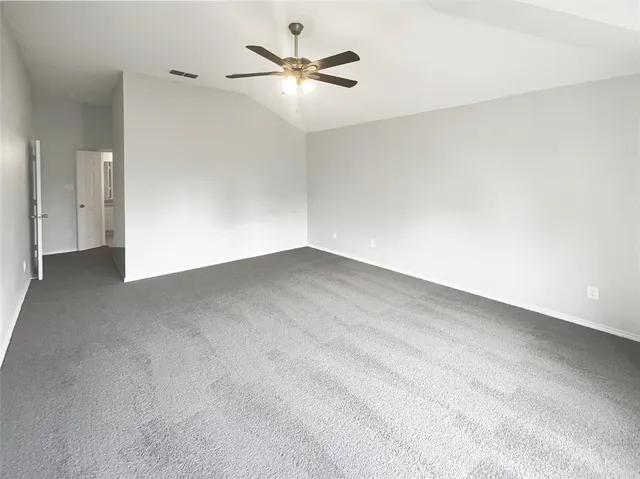 an empty room with a ceiling fan and a window