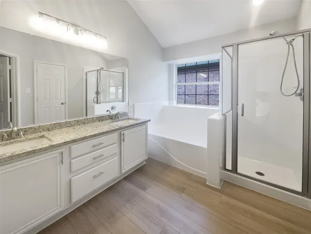 a bathroom with a granite countertop sink mirror and a bathtub