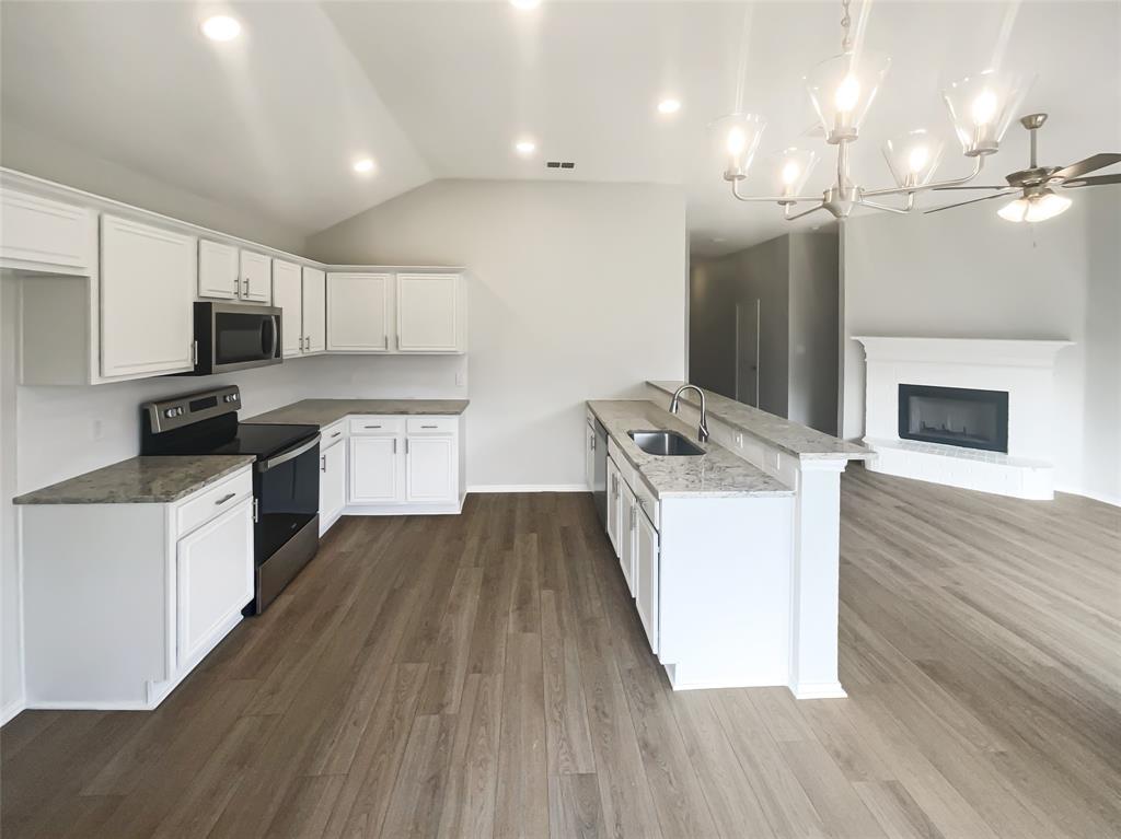 3724 Tulip Tree Drive Fort Worth, TX 76137 - Photo 5 of 30 a kitchen with a sink wooden floor stainless steel appliances and cabinets