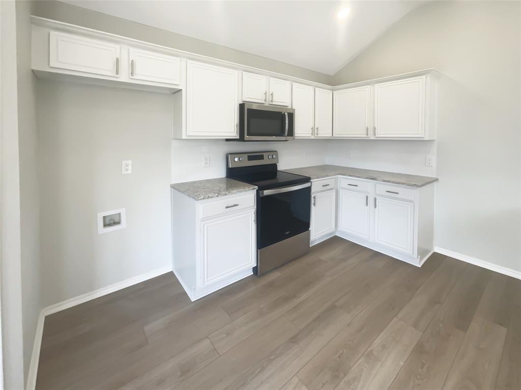 3724 Tulip Tree Drive Fort Worth, TX 76137 - Photo 6 of 30 a kitchen with a sink a microwave and cabinets