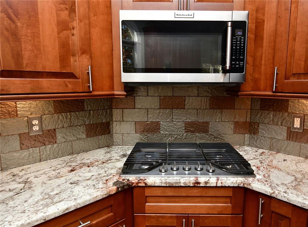 1767 Honey Tree Place Hoschton, GA 30548 - Photo 14 of 54 a stove top oven sitting inside of a kitchen