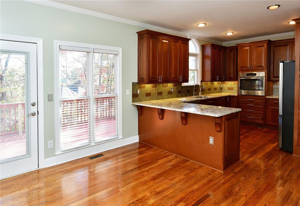 1767 Honey Tree Place Hoschton, GA 30548 - Photo 17 of 54 a kitchen with stainless steel appliances granite countertop a stove a sink and a refrigerator