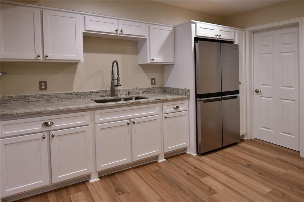 1767 Honey Tree Place Hoschton, GA 30548 - Photo 24 of 54 a kitchen with a refrigerator sink and cabinets