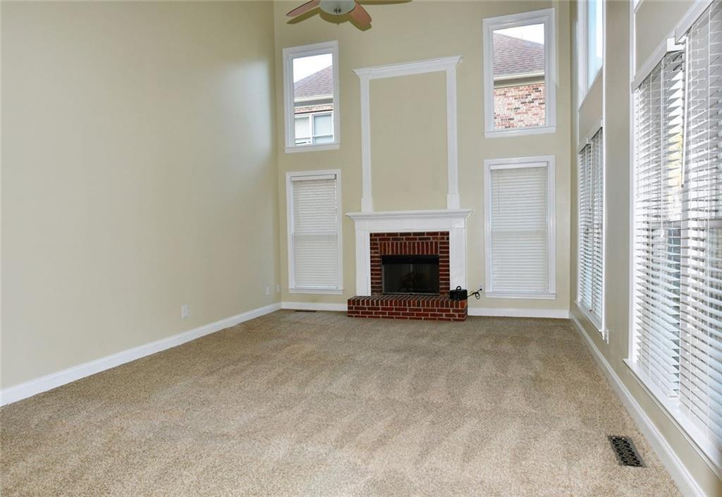 1767 Honey Tree Place Hoschton, GA 30548 - Photo 10 of 54 an empty room with windows and fireplace