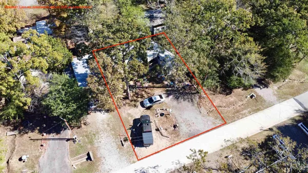 an aerial view of a house with a yard and large trees