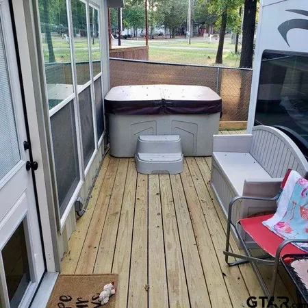 a balcony with wooden floor table and chairs