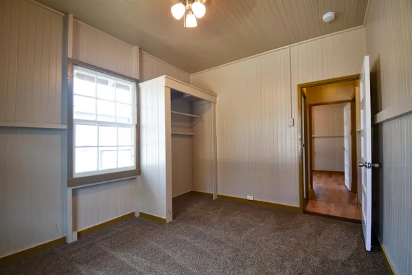 an empty room with windows and closet