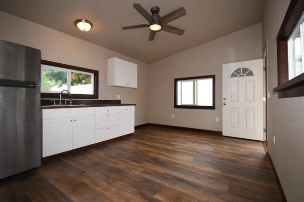 a kitchen with stainless steel appliances granite countertop a refrigerator a sink dishwasher a stove and a refrigerator with wooden floor