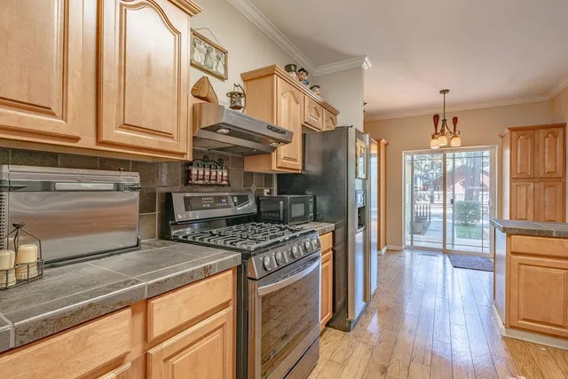 a kitchen with stainless steel appliances granite countertop a stove and a refrigerator