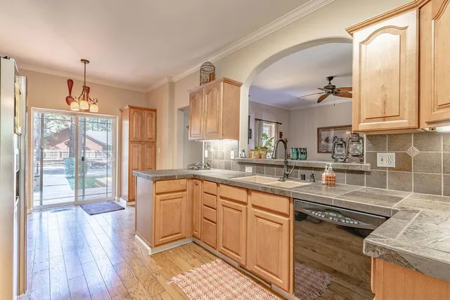 a kitchen with stainless steel appliances granite countertop a sink a stove cabinets and wooden floor