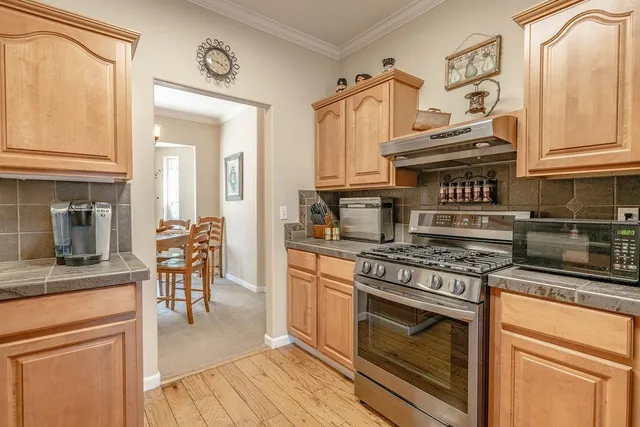 a kitchen with stainless steel appliances granite countertop a stove and a microwave