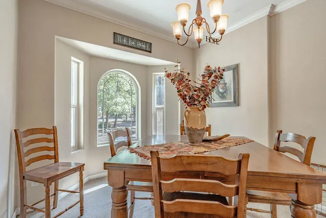 a view of a dining room with furniture wooden floor and chandelier