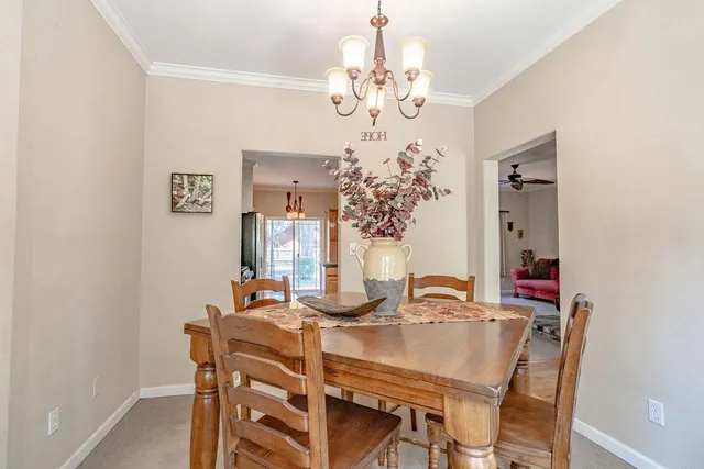 a view of a dining room with furniture and chandelier