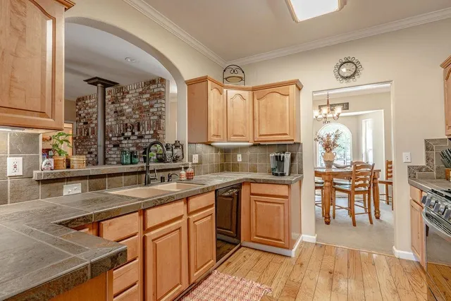 a kitchen with stainless steel appliances granite countertop sink stove top oven and cabinets