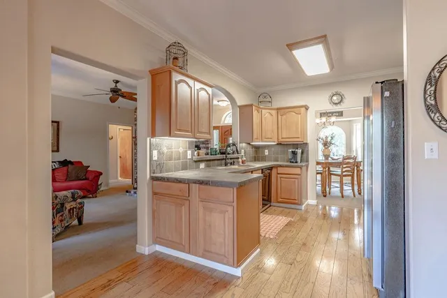 a kitchen with kitchen island granite countertop wooden cabinets and refrigerator