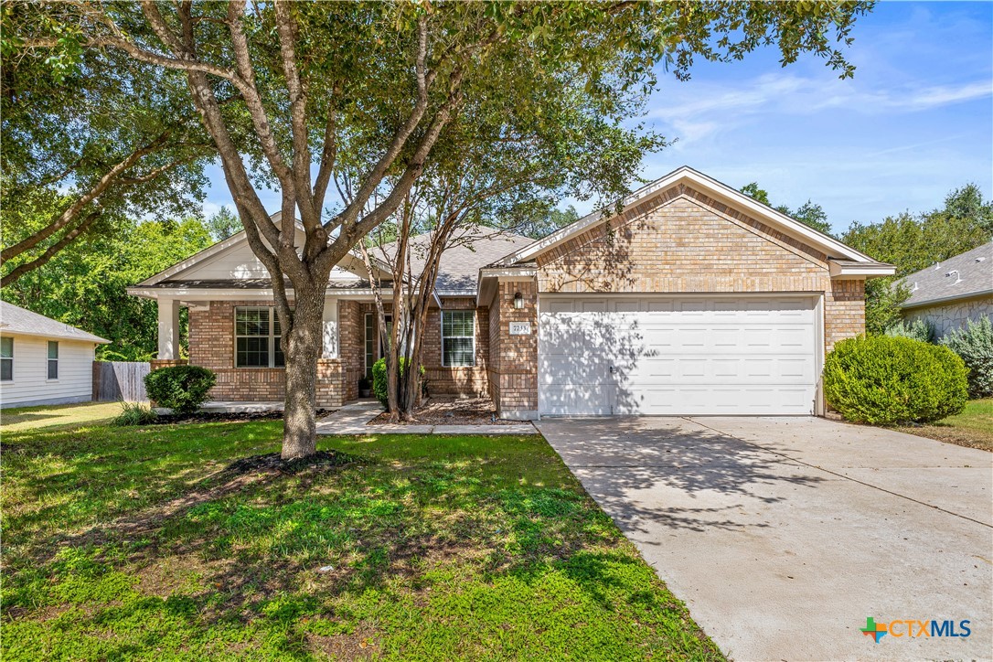 7733 Little Deer Trail Georgetown, TX 78628 - Photo 2 of 36 a front view of a house with a garden and trees