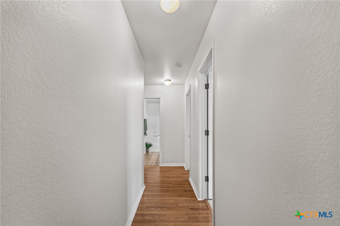 7733 Little Deer Trail Georgetown, TX 78628 - Photo 29 of 36 a view of a hallway with wooden floor and staircase