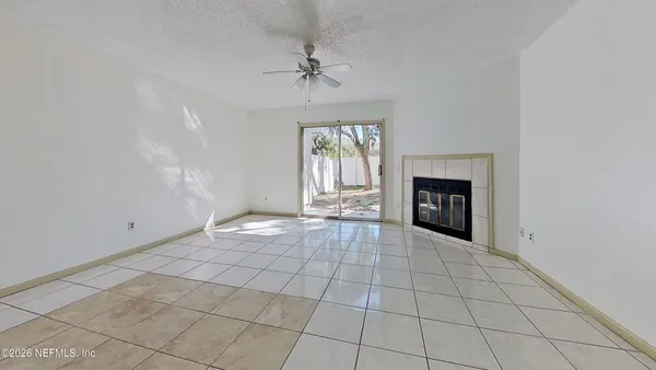 an empty room with windows and fireplace