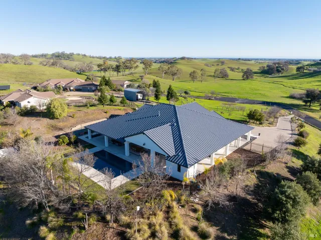 a view of a house with a yard deck and a tree