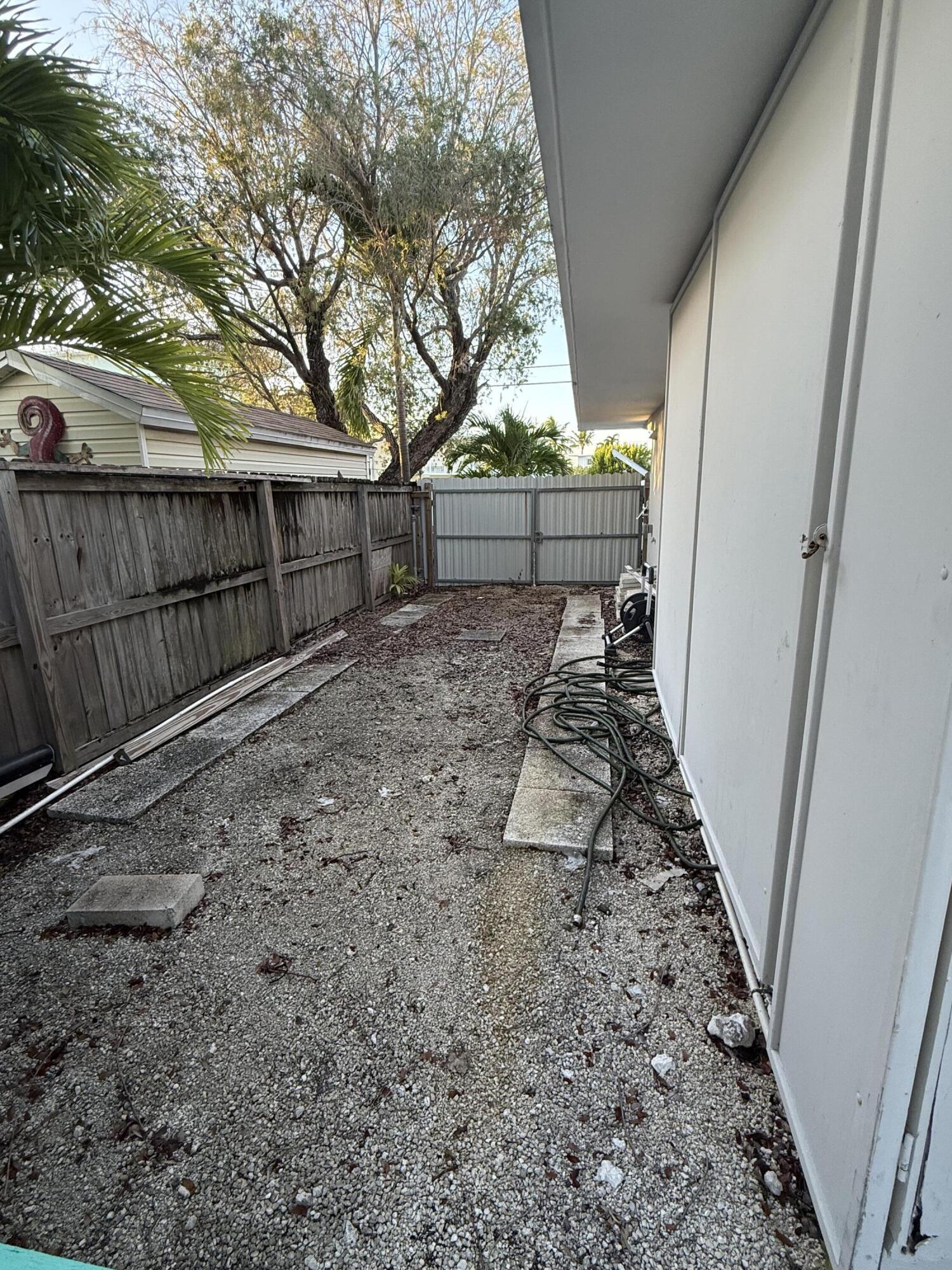 116 Long Ben Drive Key Largo, FL 33037 - Photo 25 of 26 a view of a backyard with wooden fence and large trees