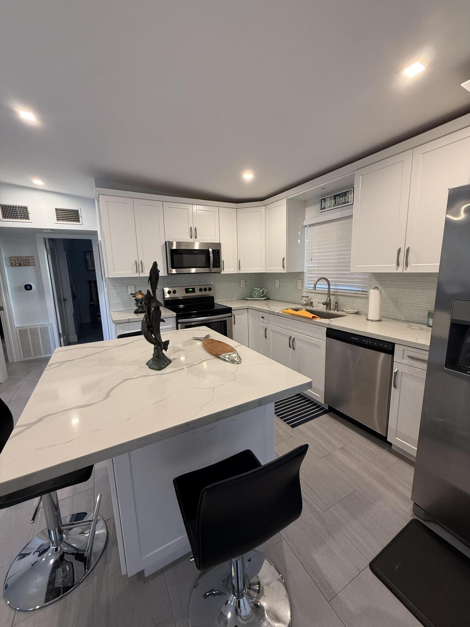 116 Long Ben Drive Key Largo, FL 33037 - Photo 5 of 26 a kitchen with a sink a stove a refrigerator and cabinets