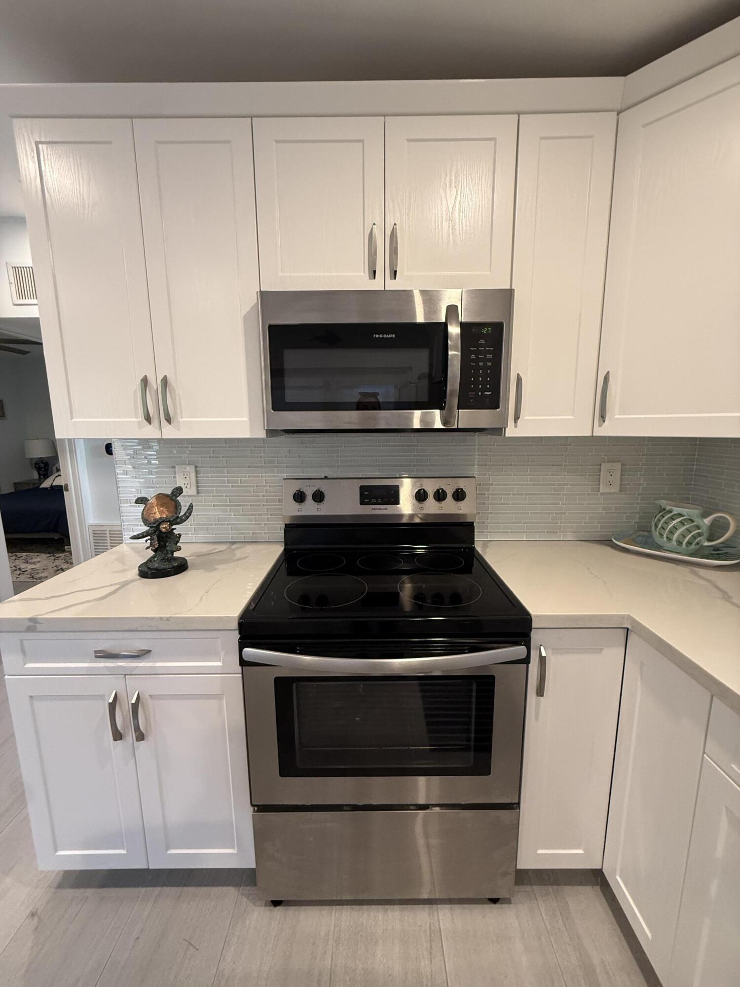 116 Long Ben Drive Key Largo, FL 33037 - Photo 6 of 26 a kitchen with white cabinets and stainless steel appliances