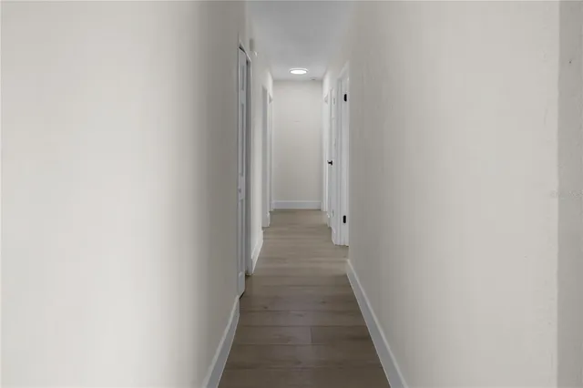 a view of a hallway with wooden floor