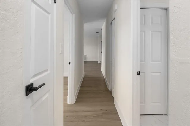 a view of a hallway with wooden floor and entryway