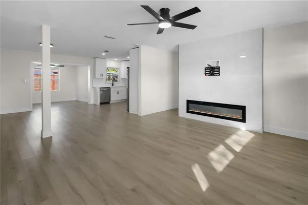 a view of a livingroom with a ceiling fan wooden floor and a ceiling fan