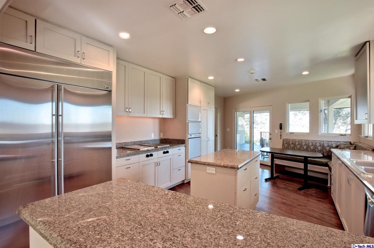 1114 Heatherside Road Pasadena, CA 91105 - Photo 12 of 35 a kitchen with stainless steel appliances granite countertop a stove refrigerator and cabinets