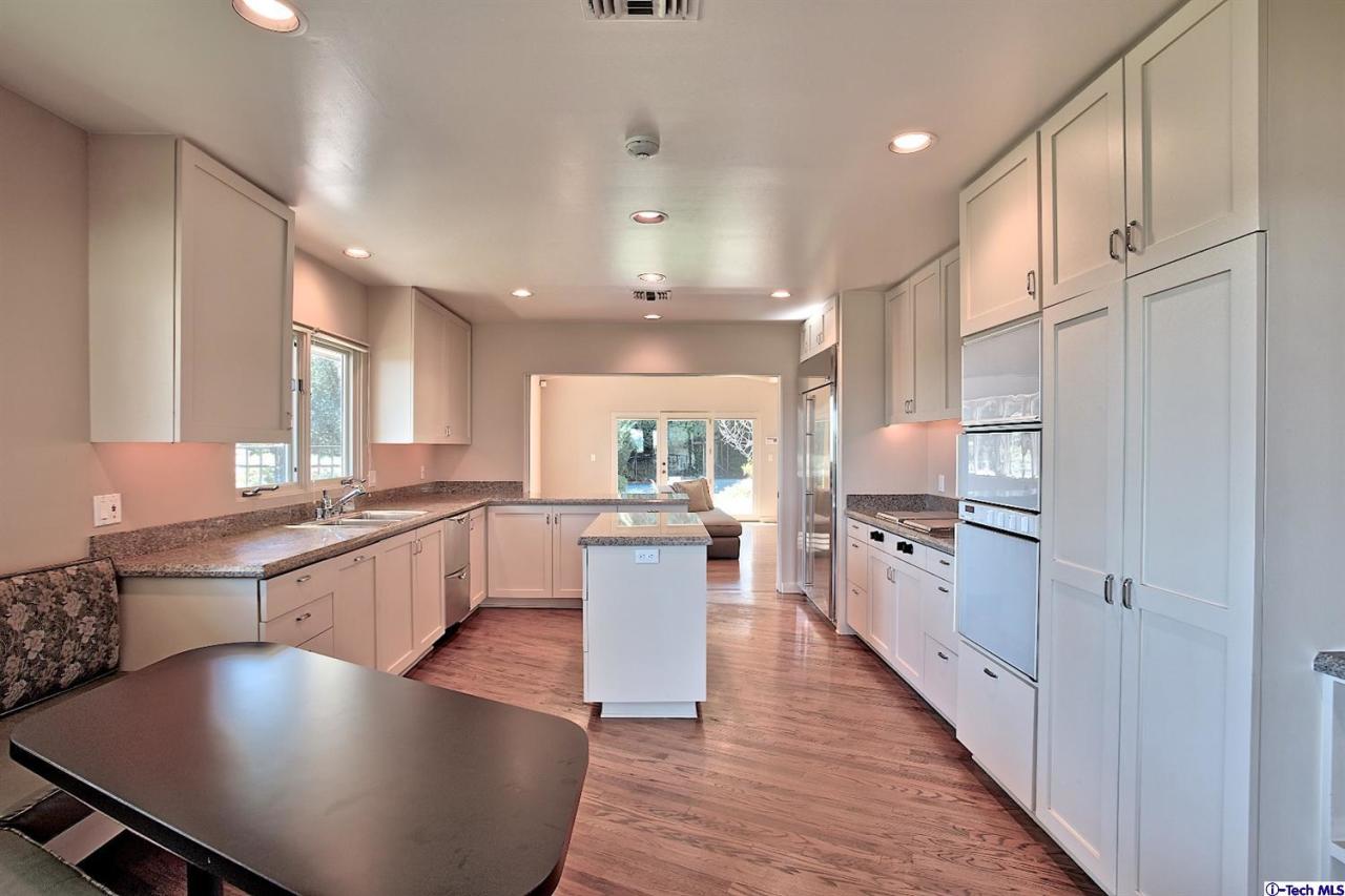 1114 Heatherside Road Pasadena, CA 91105 - Photo 10 of 35 a large kitchen with kitchen island a large counter top space a sink stainless steel appliances and cabinets