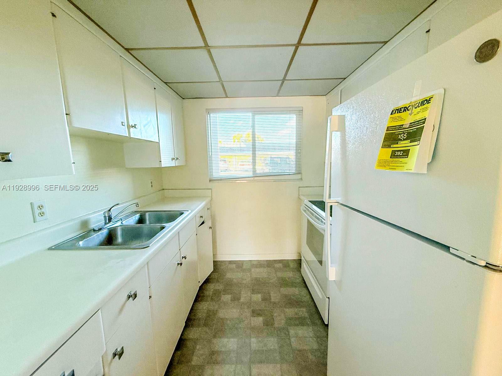 649 South Tamiami Trail, Unit 112 Venice, FL 34285 - Photo 13 of 25 a kitchen with a sink and wooden cabinets
