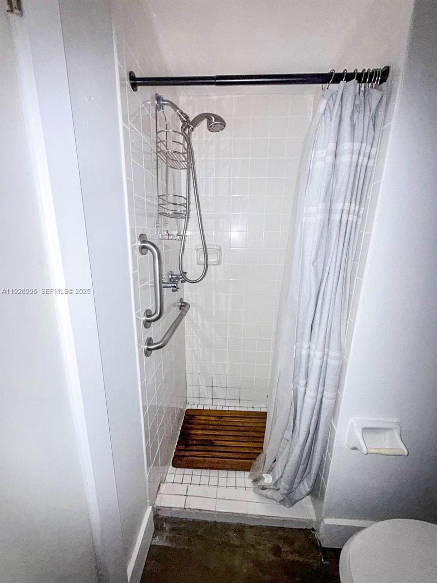 649 South Tamiami Trail, Unit 112 Venice, FL 34285 - Photo 21 of 25 a bathroom with a shower curtain and a window