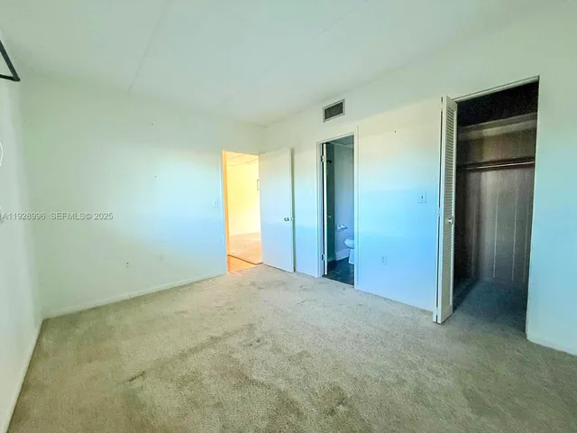 an empty room with closet and a bathroom