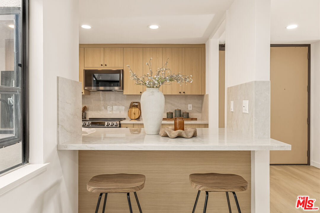 311 Bora Bora Way, Unit 3207 Marina del Rey, CA 90292 - Photo 13 of 54 a kitchen with stainless steel appliances a sink cabinets and wooden floor