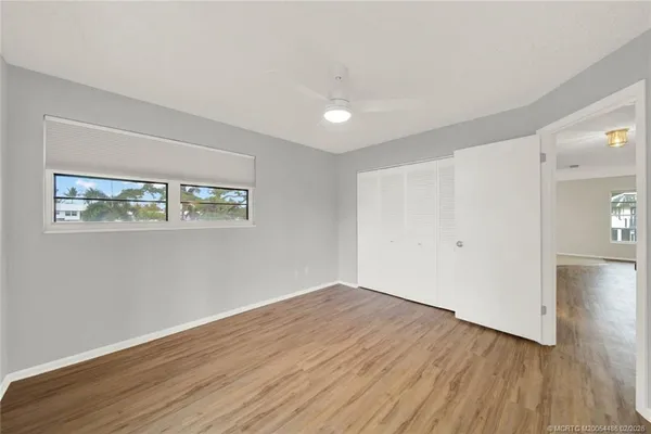 an empty room with wooden floor and windows