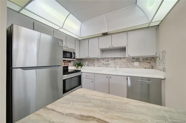 a kitchen with stainless steel appliances a refrigerator sink and cabinets