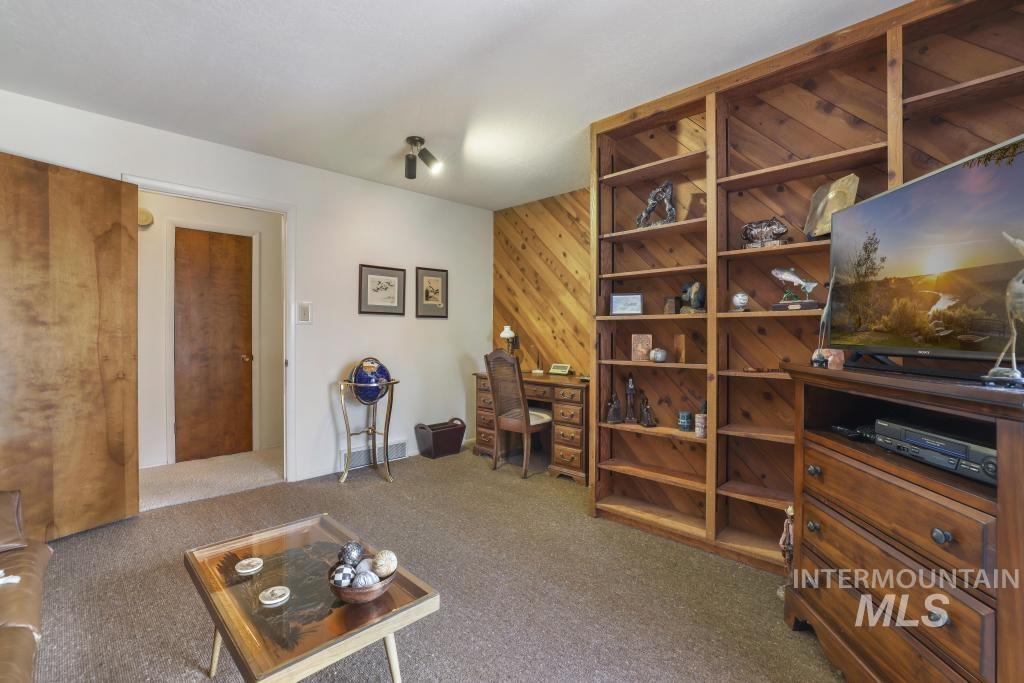 2018 Rancho Vista Drive Twin Falls, ID 83301 - Photo 35 of 50 Built-in wood shelving alongside a wood-paneled accent wall, neutral carpeting, and recessed lighting