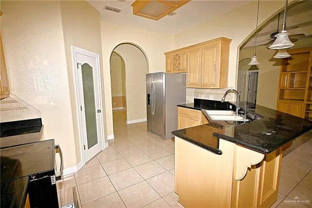 a kitchen with stainless steel appliances granite countertop a sink and a refrigerator