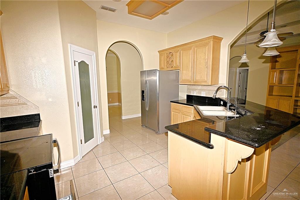 3509 Knight Avenue Edinburg, TX 78539 - Photo 17 of 18 a kitchen with stainless steel appliances granite countertop a sink and a refrigerator