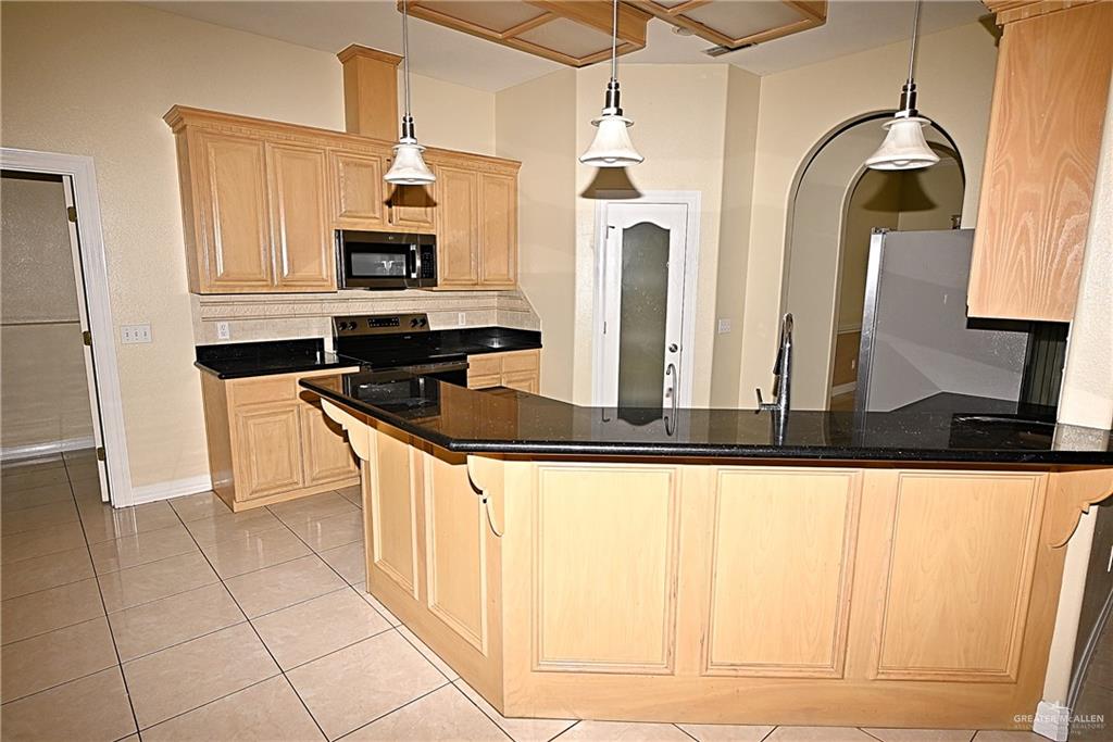 3509 Knight Avenue Edinburg, TX 78539 - Photo 3 of 18 a kitchen with stainless steel appliances kitchen island granite countertop a stove top oven a sink a counter space and cabinets