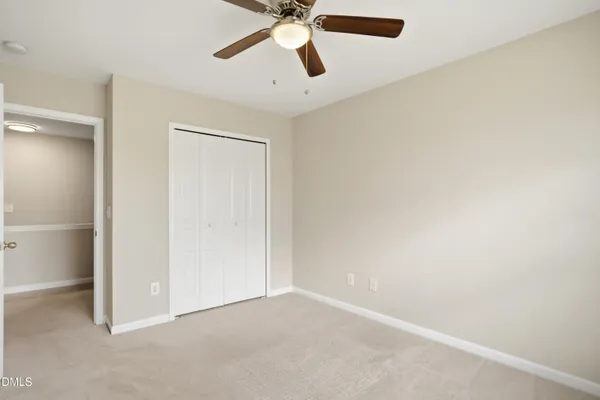 an empty room with chandelier fan