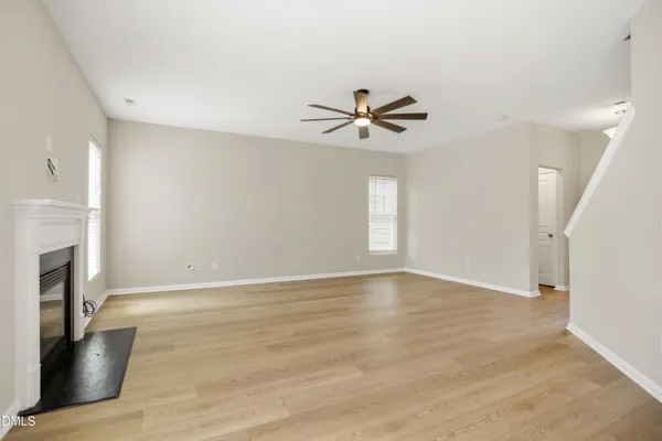 a view of an empty room with a fireplace and a window